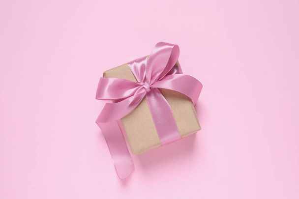 Beautiful gift box with bow on pink background, top view - Foto, Imagem
