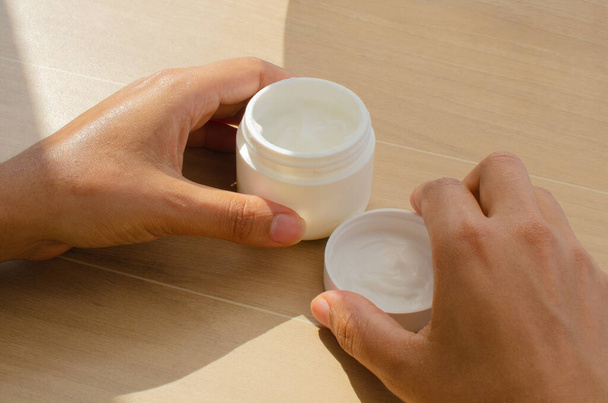 Primer plano de las manos femeninas extendiendo suavemente una crema nutritiva para hidratar la piel. - Foto, Imagen