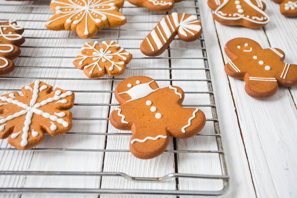 Gingerbread cookies on white wooden table, Christmas people and snowflakes figures - Photo, Image