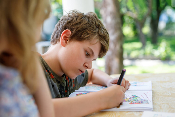 Preteen School Boy zeichnen mit Filzstiften. Zurück zur Schule. Kaukasische kleine Schuljunge zeichnen Bild zu Hause. Hobby, Bildungskonzept - Foto, Bild