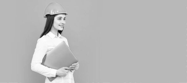 Young woman construction manager. Woman builder isolated portrait with protect helmet and laptop computer. Woman isolated face portrait, banner with mock up copy space - Foto, immagini