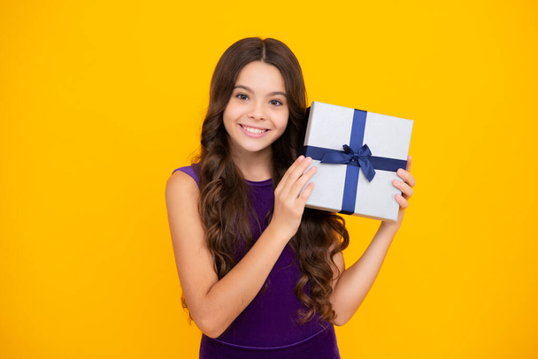 Glückliches Mädchengesicht, positive und lächelnde Emotionen. Teenager-Kind mit Geschenkbox. Teen Mädchen geben Geburtstagsgeschenk. Geschenk, Gruß und Geschenkidee - Foto, Bild