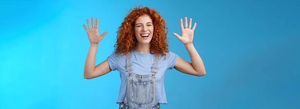 Fine you won. Cheerful carefree playful attractive redhead curly girlfriend having fun laughing out loud joyful raise hands up surrender fool around enjoy cool awesome time spending friend. Copy space - 写真・画像