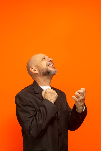 Man in suit jacket, bearded and bald looking up and making gestures. stress at work - Photo, image