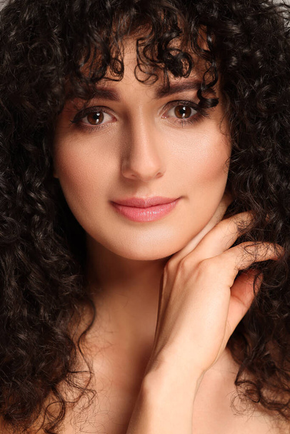 Beautiful young woman with long curly hair - Fotografie, Obrázek