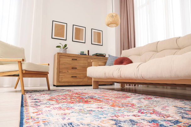 Piękny dywan, sofa, fotel i komoda w środku, widok z niskiego kąta - Zdjęcie, obraz
