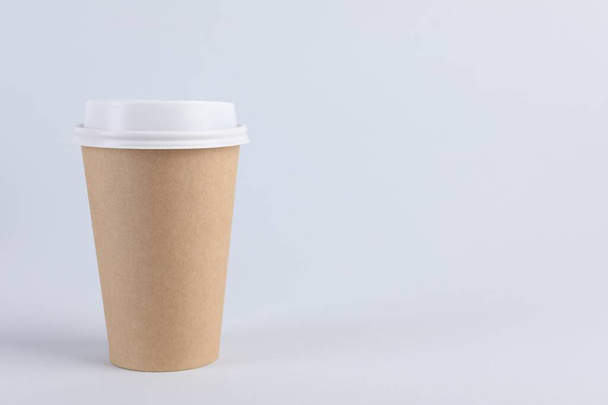Paper cup with plastic lid on light background, space for text. Coffee to go - Photo, image
