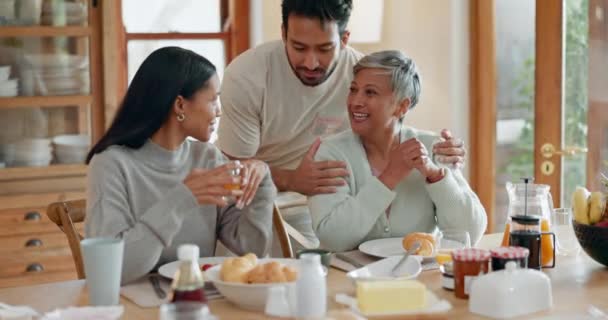 Knuffel, koppel en familie ontbijt aan een tafel thuis voor gezondheid en welzijn. Een moeder met een getrouwde man en vrouw of vrienden samen in de eetkamer met liefde, zorg en gesprek over eten. - Video