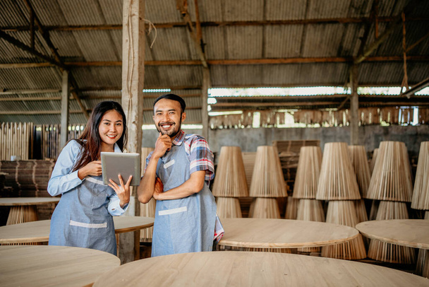 Male and female entrepreneur couple smiling at the camera holding a tablet at a woodcraft shop - Fotografie, Obrázek