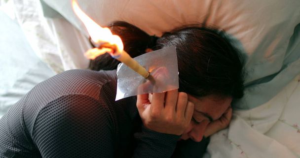 Person applying ear candling to remove ear wax - Photo, Image