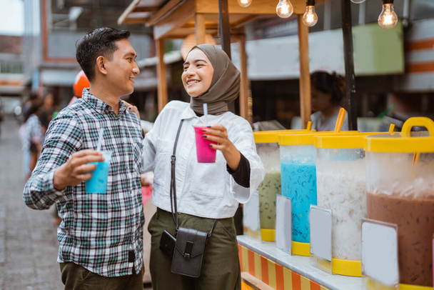 portrait of happy young muslim couple buy drink from a street vendor - Zdjęcie, obraz