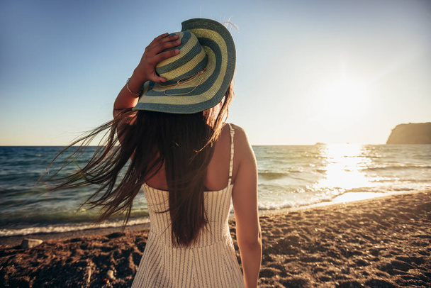 Teenage dívka má krásný výhled na moře a západ slunce. Koncept cestování, dovolená. - Fotografie, Obrázek