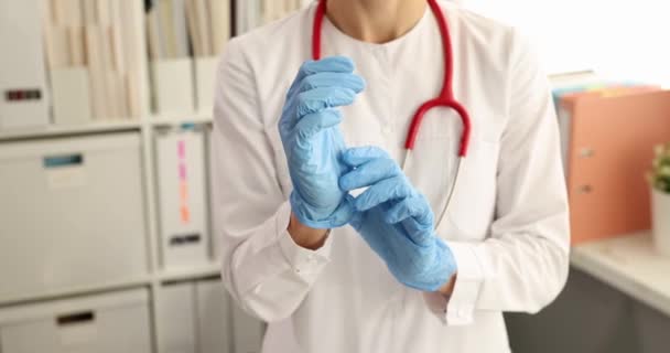 El doctor pone guantes desechables a la mano en el consultorio médico. Concepto de profesión proctologista - Metraje, vídeo