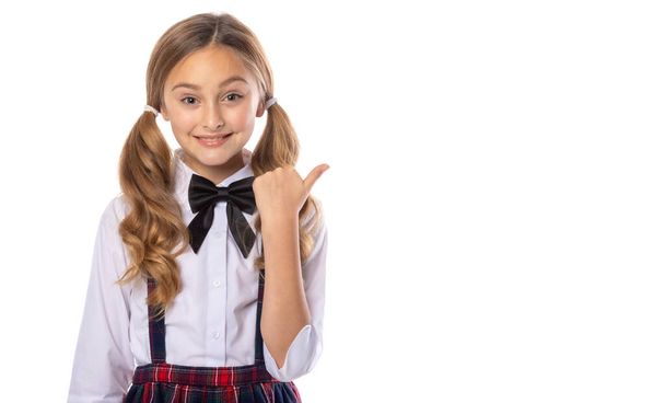 Positive school girl, pointing finger to the right copy space. Promoter isolated over white color background. Education, back to school. - Photo, image
