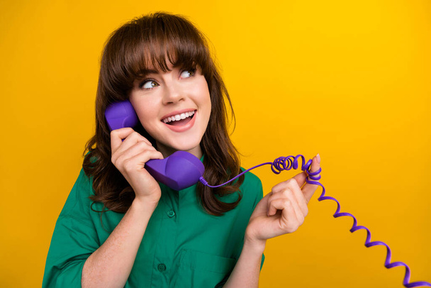 Photo of dreamy girly lady wear green shirt speaking phone looking empty space isolated yellow color background. - Foto, Bild