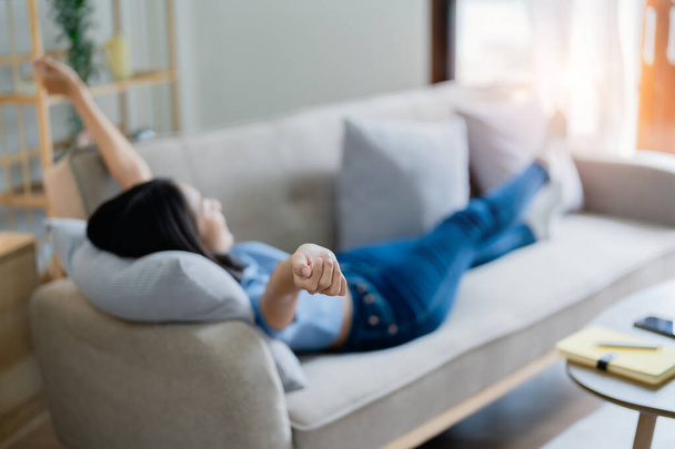 Home Lifestyle Frau entspannt schlafen auf dem Sofa Patio Wohnzimmer. Glückliche Dame legt sich auf bequeme Kissen und macht ein Nickerchen für Wohlbefinden und Gesundheit. Tropenurlaub - Foto, Bild