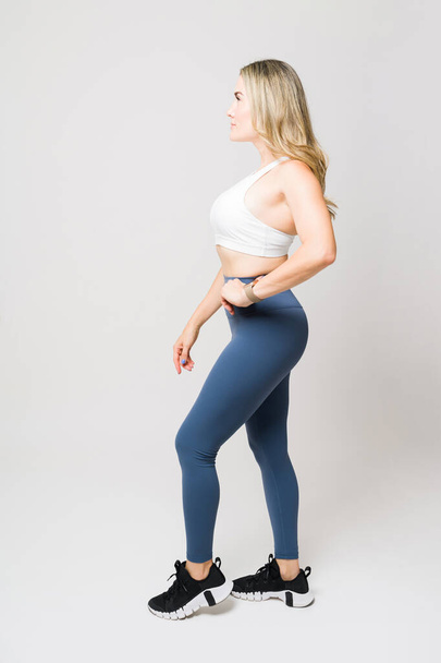 Profilja egy sportos vonzó nő egy fitt zsákmány és a test készen áll az ő edzés vagy képzés visel aktív ruha  - Fotó, kép