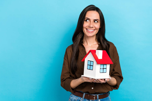 Photo of young student hispanic lady holding building apartment dreaming look empty space insurance ad isolated on blue color background. - Foto, Imagem