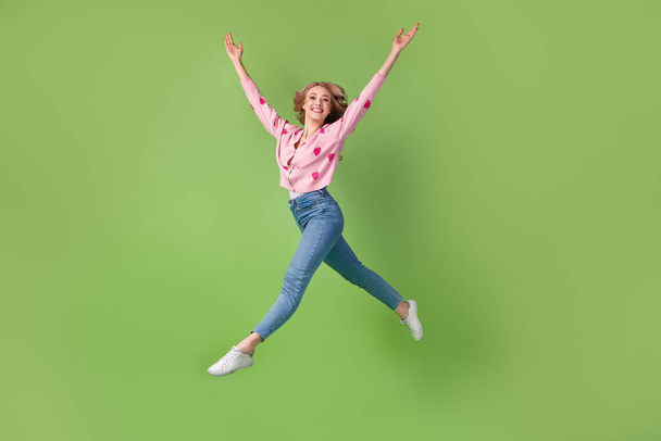Full size profile portrait of gracious stunning girl jumping run raise hands isolated on green color background. - Zdjęcie, obraz