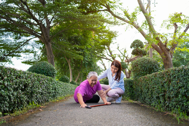 Asian senior woman fell down on lying floor because faint and limb weakness and Crying in pain form accident and her daughter came to help support. Concept of old elderly insurance and health care - Foto, afbeelding