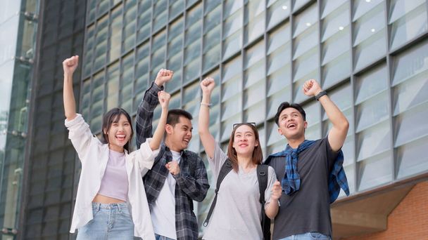 Group of happy young entrepreneurs with hands up and laughing to celebrate and excited success for achievements obtained. Undergraduate students celebrate success after end project, teamwork concept - Фото, изображение