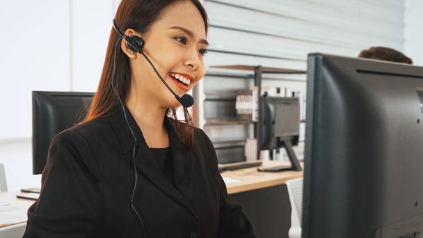 Business people wearing headset working in office to support remote customer or colleague. Call center, telemarketing, customer support agent provide service on telephone video conference call. Jivy - Photo, Image