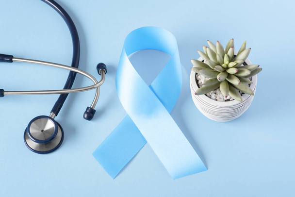 Cinta azul de sensibilización contra el cáncer con estetoscopio sobre fondo claro - Foto, imagen