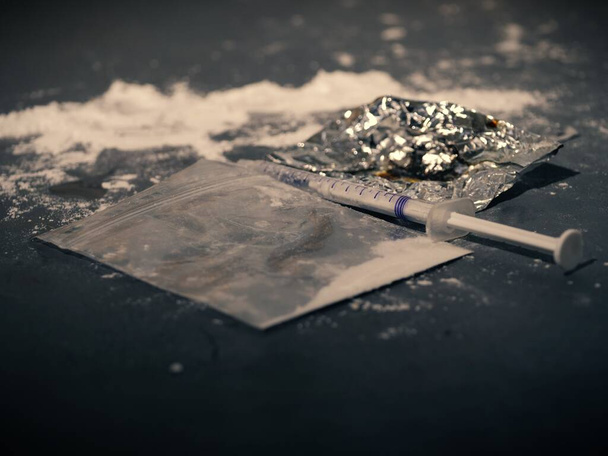 Heroin powder burned on tin foil for injection close up selective focus - Photo, Image