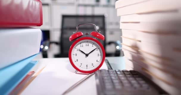 Reloj despertador rojo y papeles de trabajo en el lugar de trabajo. Concepto de horas extraordinarias y plazo - Metraje, vídeo