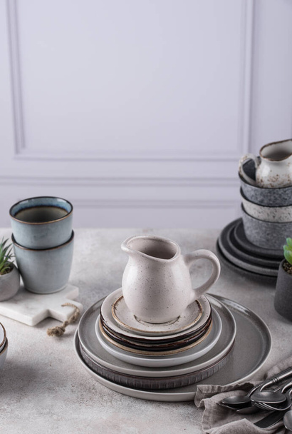 Kézműves kerámia asztali eszközök, tányérok, tálak és poharak. Skandináv stílus - Fotó, kép