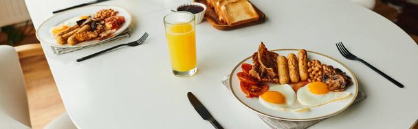 Leckeres Frühstück mit Spiegeleiern, Würstchen und Orangensaft auf dem heimischen Tisch, Banner - Foto, Bild