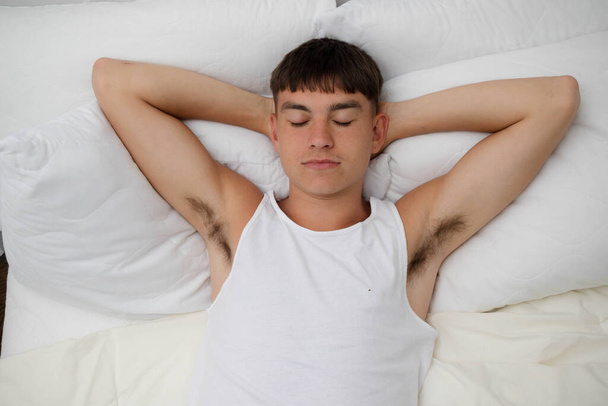 Young single male adult asleep on top of his bed - Foto, Imagen