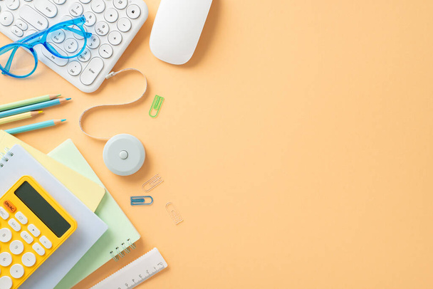 Inspire students and parents alike with this captivating photograph. Collection of colorful stationery and gadgets on a pastel orange background, offering perfect space for your text or advertisement - Photo, Image