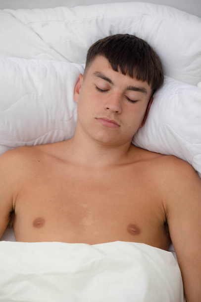 Young single male adult asleep shirtless on his back; in his bed - Φωτογραφία, εικόνα