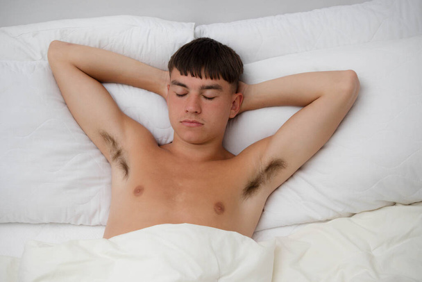 Young single male adult asleep shirtless on his back; in his bed - Zdjęcie, obraz