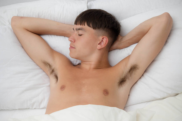 Young single male adult asleep shirtless on his back; in his bed - Zdjęcie, obraz