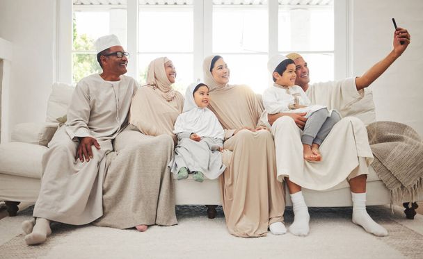 Selfie, islam i duża rodzina na kanapie z uśmiechem, dziadkowie i rodzice z dziećmi w arabskim domu. Portret muzułmanów, kobiety w hidżabie i szczęśliwe dzieci, pokolenia siedzące razem na kanapie - Zdjęcie, obraz