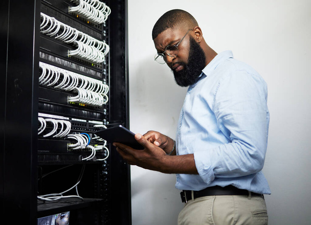 Data center, tablet and serious technician man with cables for internet connection for software programming. Engineer black person with tech for cybersecurity, wire or problem solving in server room. - Foto, Imagem