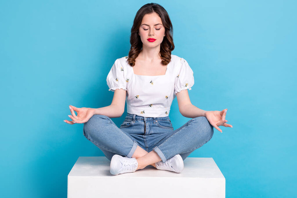 Full length photo of charming dreamy girl dressed white top closed eyes enjoying yoga isolated blue color background. - Фото, зображення