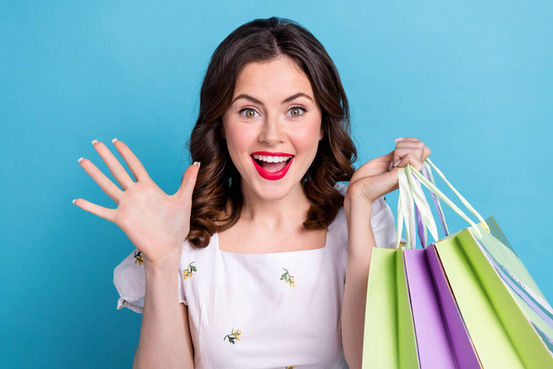 Photo portrait of pretty girl pouted hold shopping bags wave hand excited dressed stylish blue outfit isolated on pink color background. - 写真・画像