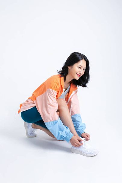healthy beauty concept photo of korean asian beautiful woman tying shoelaces - Zdjęcie, obraz