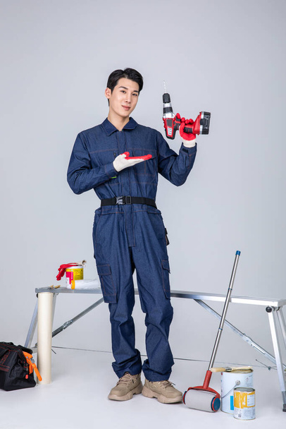 millennials and gen z, korean asian young man, site staff with drill - Fotografie, Obrázek