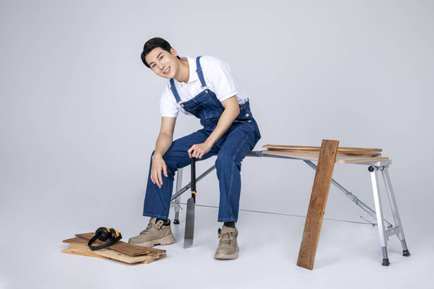 millennials and gen z, korean asian young man carpenter holding tablet pc - Фото, изображение