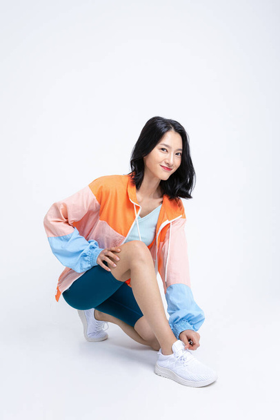 healthy beauty concept photo of korean asian beautiful woman tying shoelaces - Photo, Image