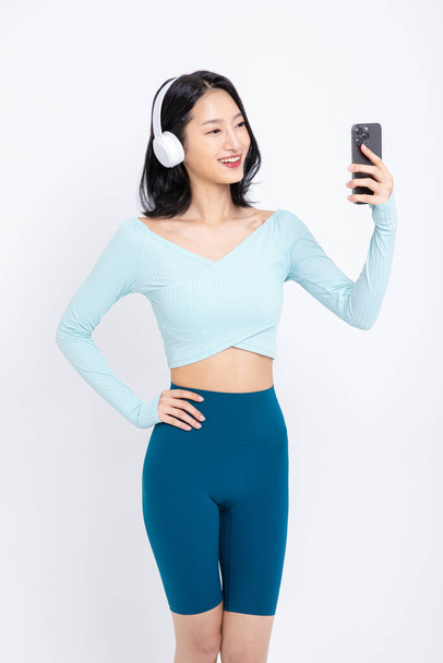 healthy beauty concept photo of korean asian beautiful woman wearing a headphones and listening to music - 写真・画像