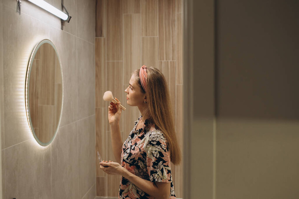 Blondi tyttö tekee meikkiä peilin edessä - Valokuva, kuva
