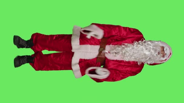 Vertical video Edessä näkymä joulupukki tuntuu ylityöllistetty, tekee aikalisä merkki ilmaista loppuun ja pyytää taukoa studiossa. Kausiluonteinen hahmo juhlapuvussa on väsynyt, kieltäytyy työskentelemästä - Materiaali, video