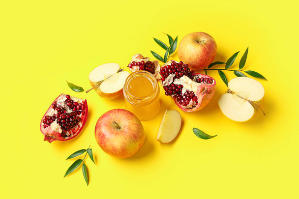 Samenstelling met rijp fruit en honing op gele achtergrond. Rosh hashanah (Joods Nieuwjaar) viering - Foto, afbeelding