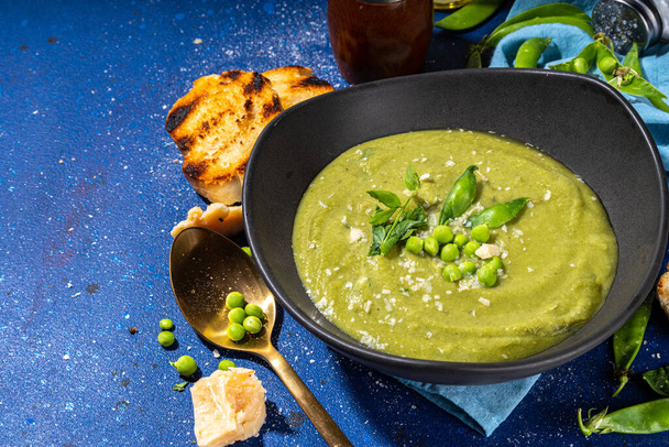 Házi készítésű zöldborsókrém leves, zöld gazpacho hideg leves borsó dekorációval és krutonnal, ízletes vegán ételek, diétás vacsora recept - Fotó, kép