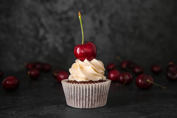 Ízletes cseresznye cupcake fekete háttér - Fotó, kép